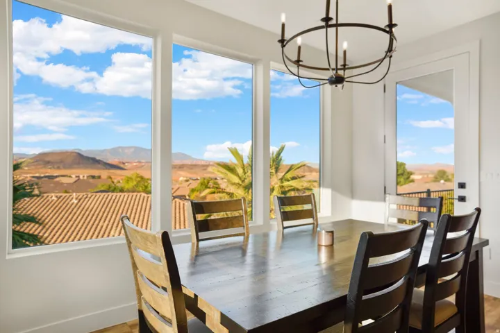 Spacious room featuring multiple large windows, a single glass-paneled door, and a dark metal chandelier