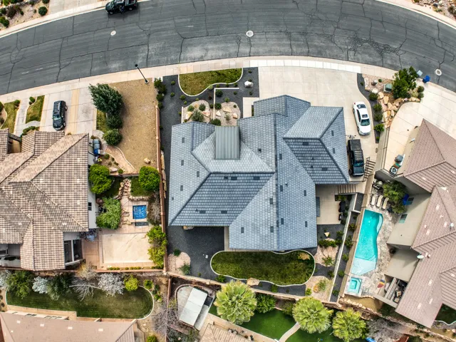 Aerial view - multi-pitched roof design, integrated garage, concrete driveway, and established landscaping