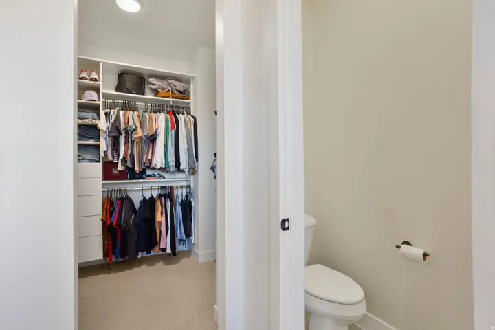 Primary bedroom closet - custom walk-in closet system with integrated shelving and hanging rods