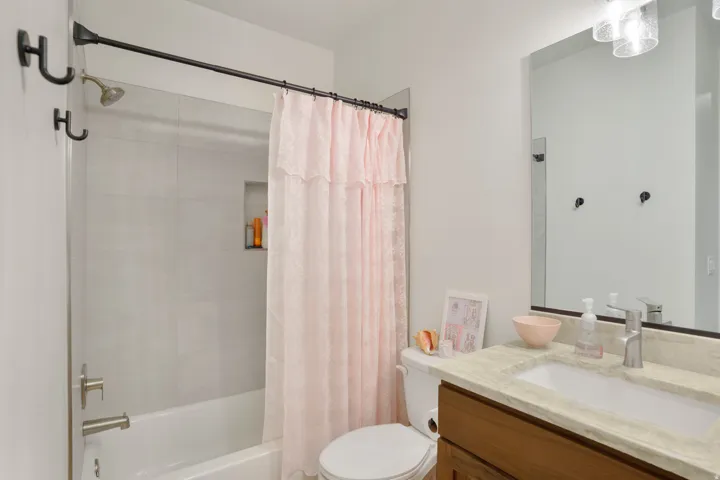 Bathroom featuring a tub/shower combination with light-toned wall tile and a built-in shower niche