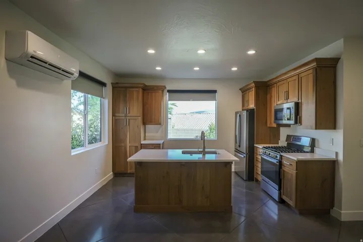 ADU - Kitchen featuring wood cabinetry, stainless steel appliances, a center island with sink, and recessed lighting