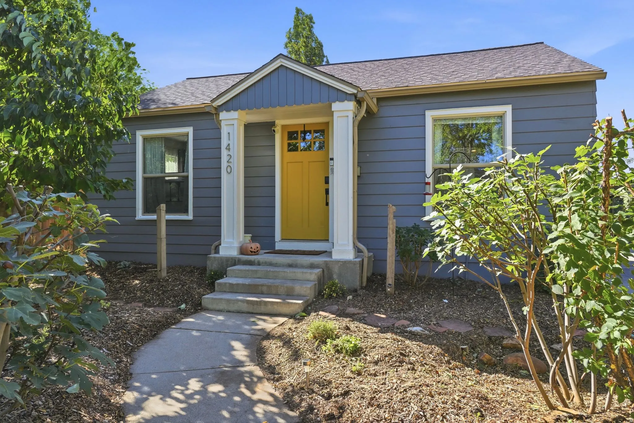 Blue siding exterior with a bright yellow front door