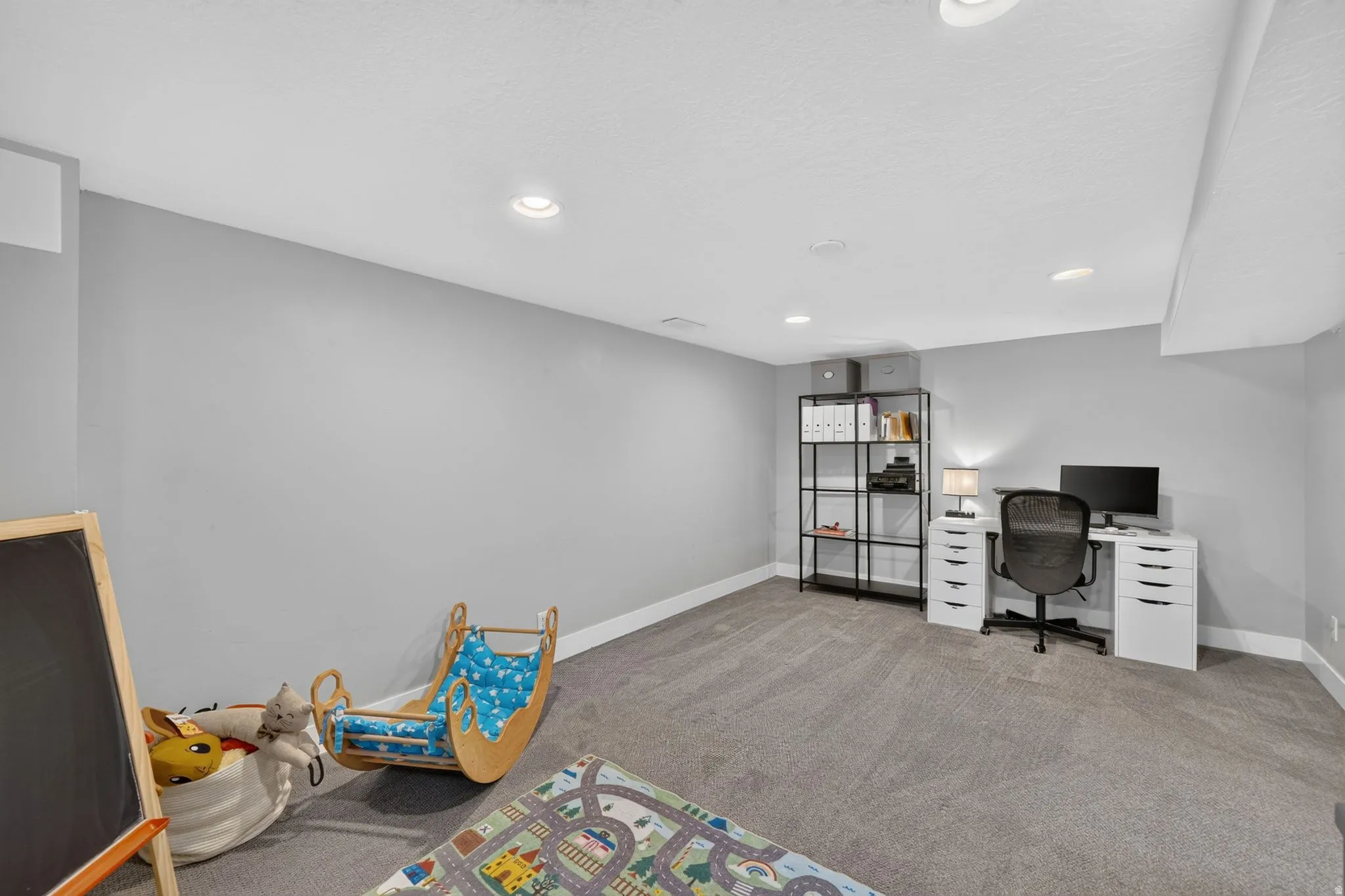 Spacious room featuring neutral carpeting and recessed lighting