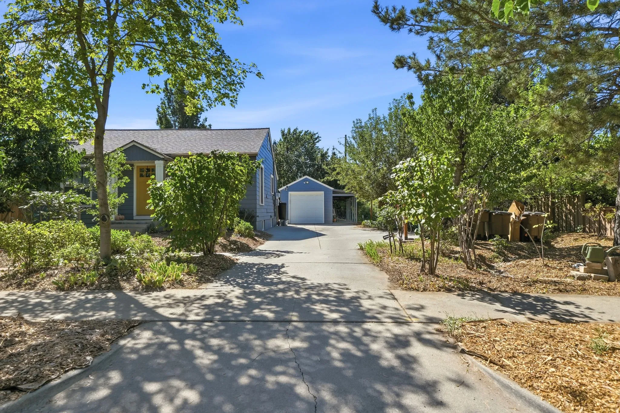 Split-level residence featuring a detached garage with an overhead door, and a paved driveway