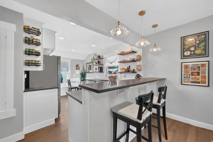 Kitchen island with a dark countertop and white cabinetry