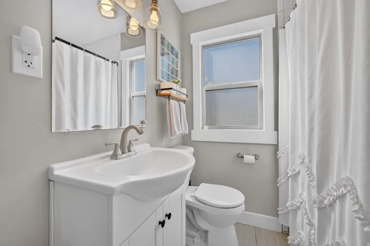 White vanity with integrated sink and brushed nickel faucet