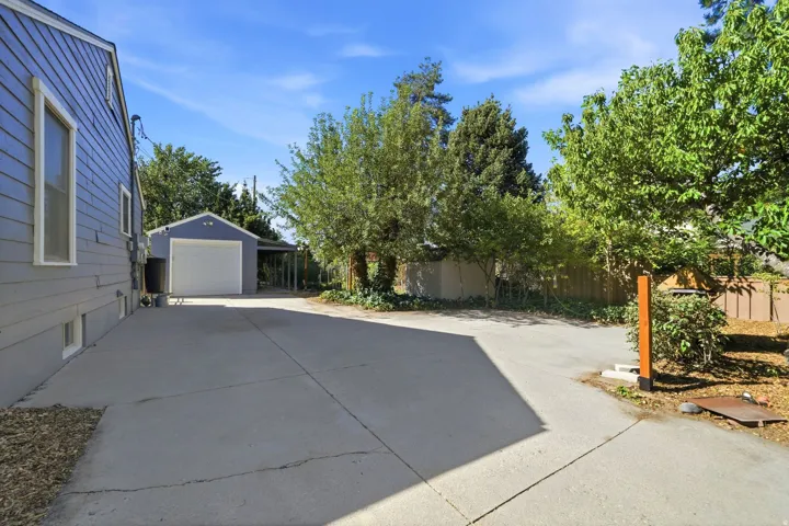 Detached garage structure with an attached carport, and a paved driveway
