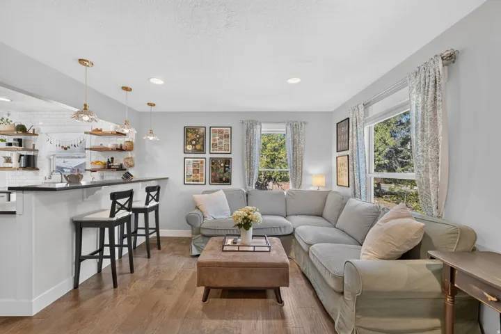 Hardwood-finish flooring throughout, white subway tile backsplash, built-in shelving, recessed ceiling lighting, and pendant lighting
