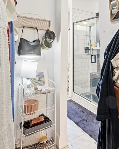 Shower enclosure with subway tile surround, glass door, and black fixtures