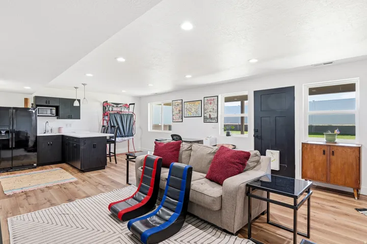 Open-concept living area featuring wood-finish flooring, recessed lighting, and multiple windows