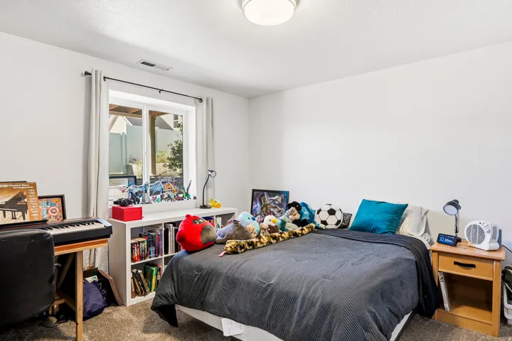White walls, recessed window with white trim, light-colored carpet, and a flush-mount ceiling light fixture