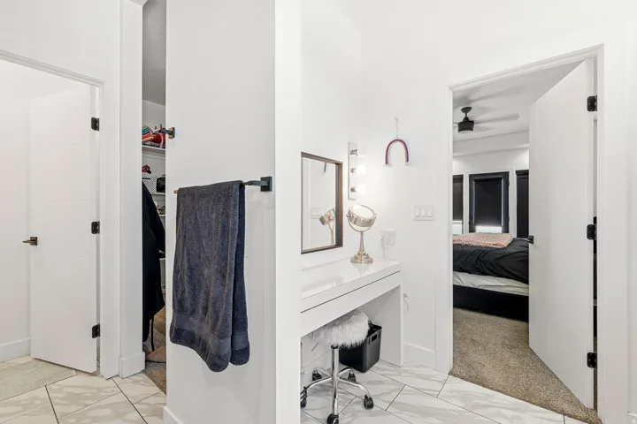 White interior doors with black hardware, white walls, light-colored tile flooring, and carpeted area