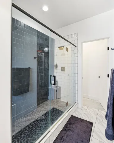 Glass-enclosed shower with black-framed fixtures