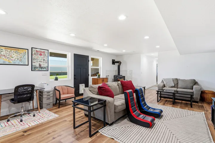 Open-concept living space with wood-finish flooring, recessed lighting, and a dark-paneled door