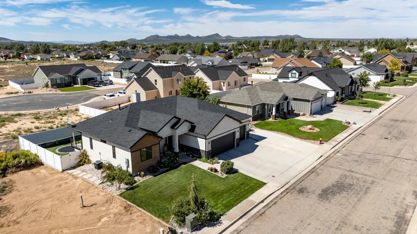 Contemporary exterior with a dark shingle roof, attached garage, and a manicured front lawn