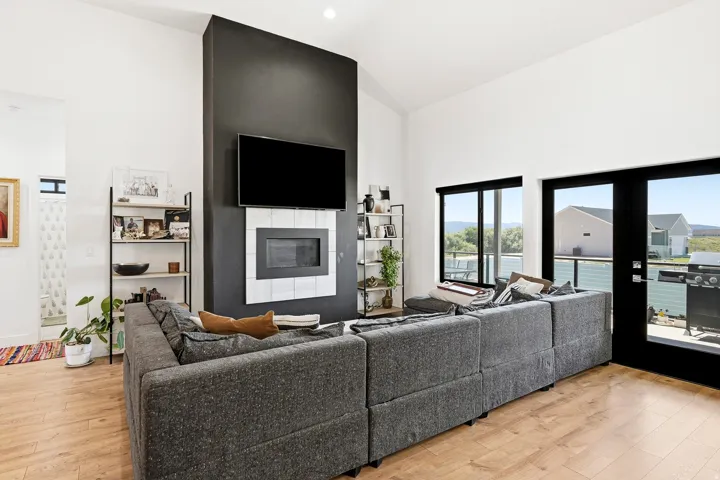 Vaulted ceilings with recessed lighting, wood-finish flooring, and a fireplace with tile surround