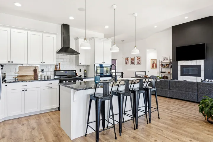 Kitchen featuring white shaker cabinetry, subway tile backsplash, and a central island with counter seating