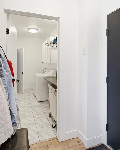 Laundry area with white cabinetry, a utility sink, and stone-finish countertops
