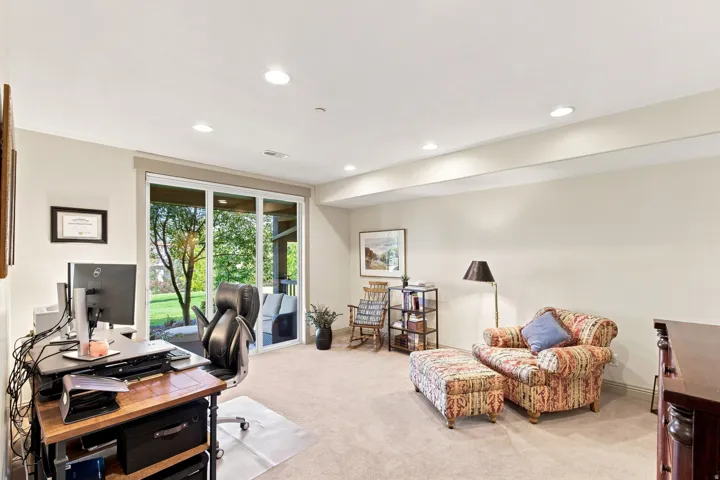 Recessed lighting illuminates the carpeted flooring and light-colored walls