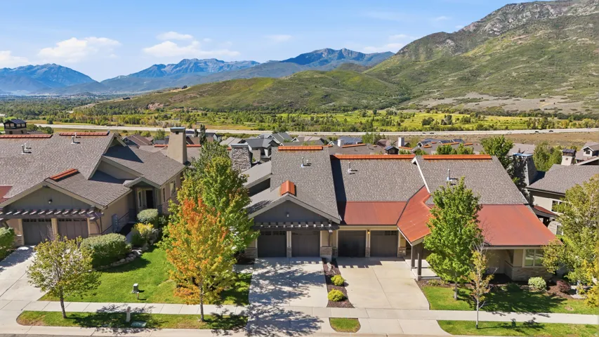 Front exterior featuring a multi-car driveway, attached garages, and a prominent mountain backdrop