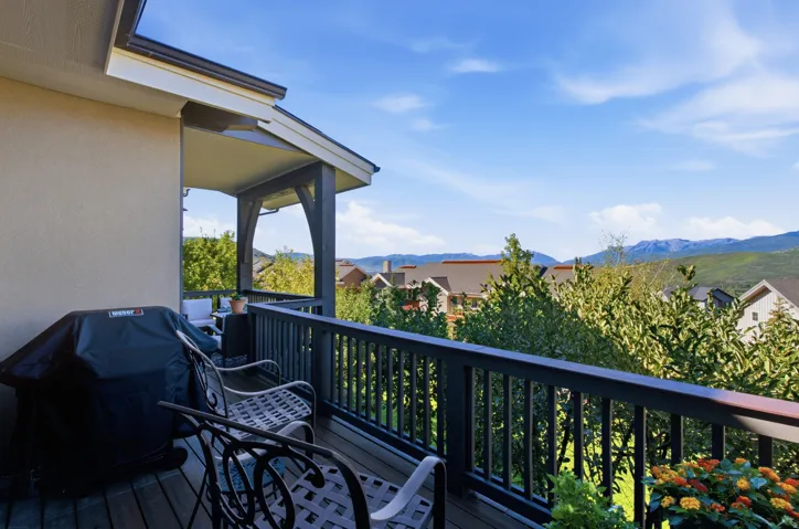 Covered outdoor balcony with wood decking and painted railing