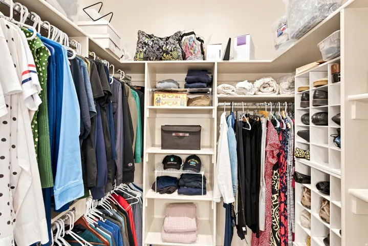 Built-in closet system featuring multiple hanging rods, adjustable shelving, and dedicated shoe cubbies