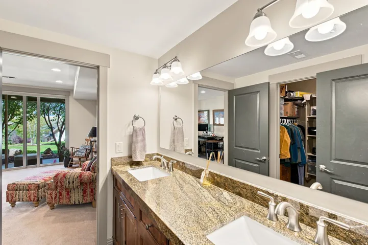Dual basin vanity with a stone countertop and brushed nickel fixtures