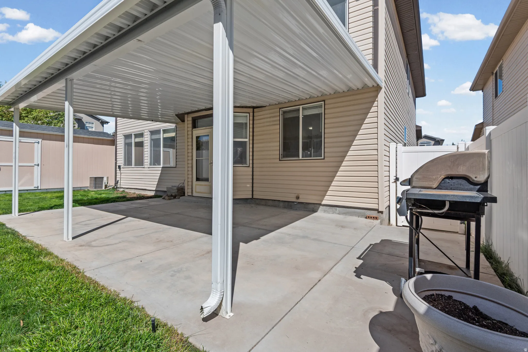 Concrete patio with overhead covering, exterior siding, and a privacy fence