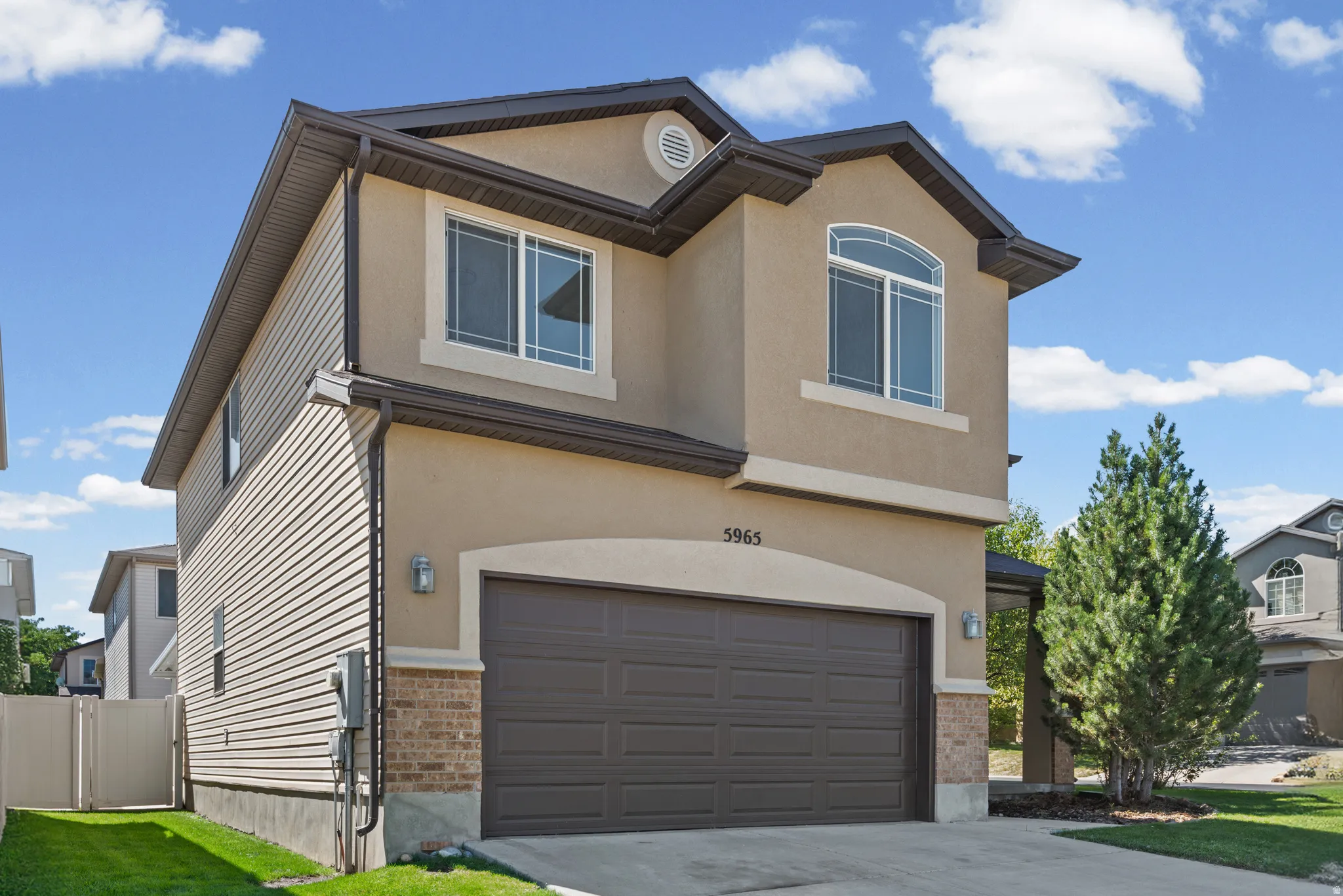 Two-story stucco and siding exterior with a dark roof