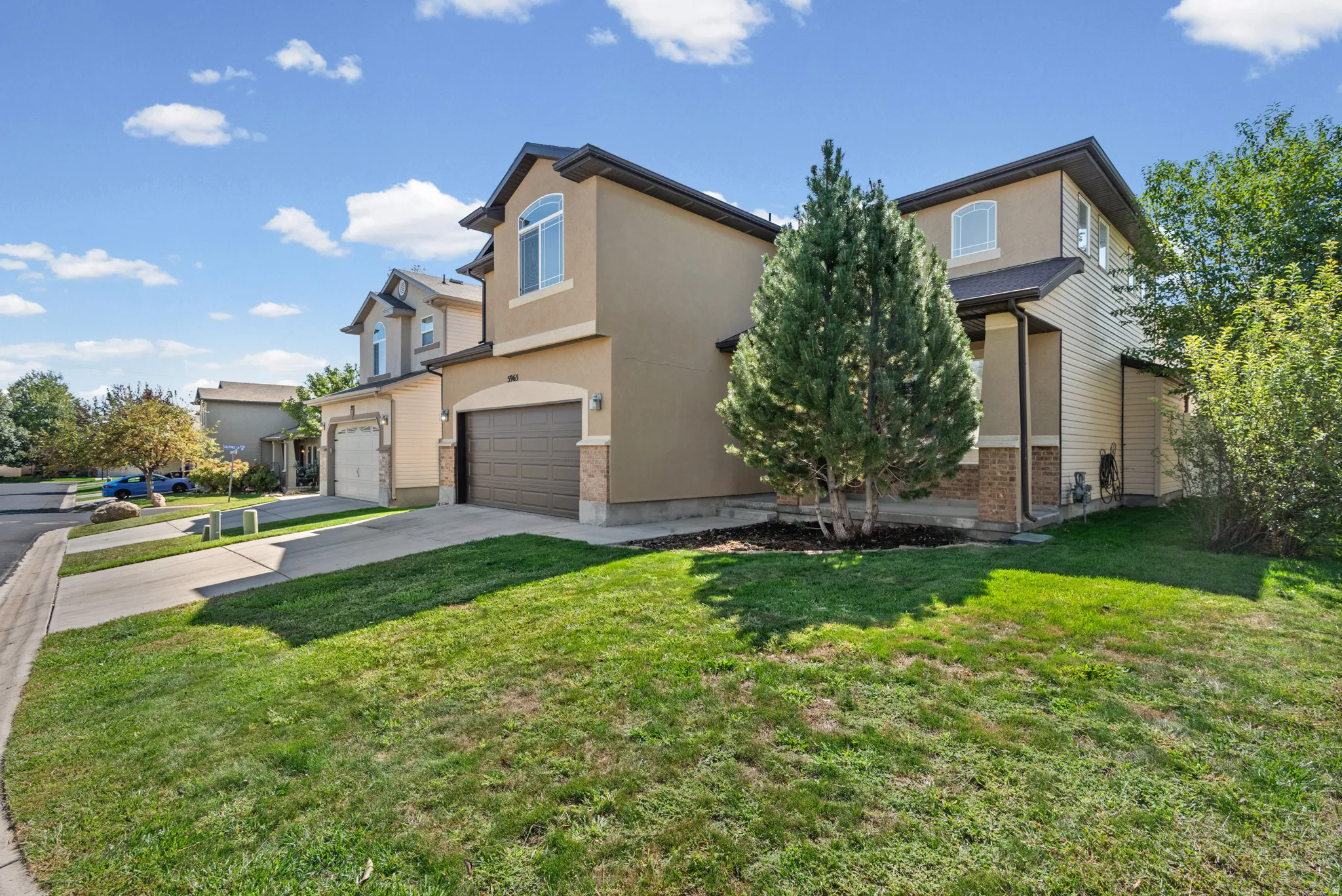 Two-story stucco and siding exterior with stone accents