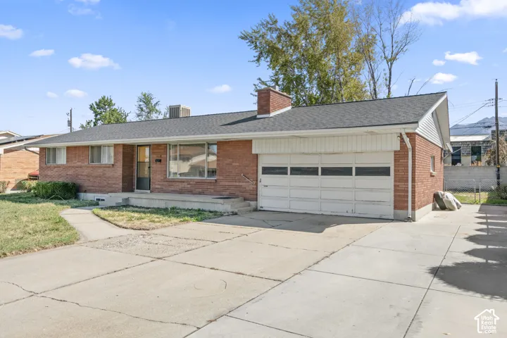 Brick exterior with a dark-shingle roof, an attached two-car garage, and a concrete driveway