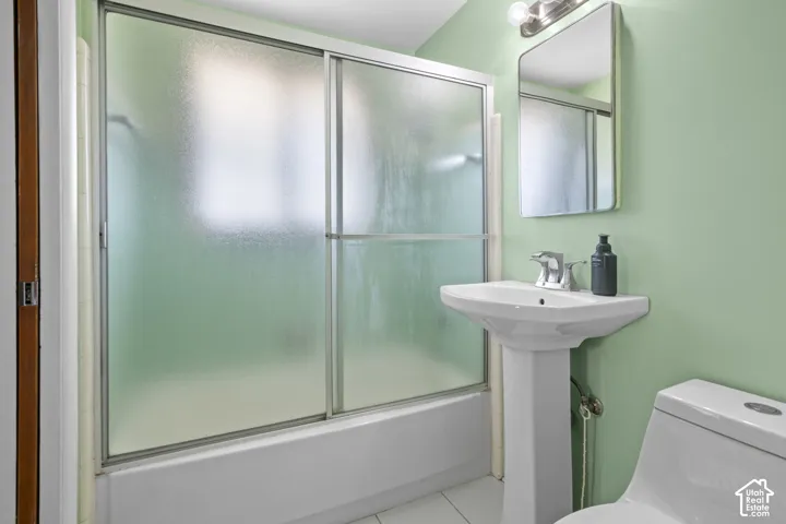 Pedestal sink with chrome faucet, wall-mounted mirror, and overhead vanity lighting