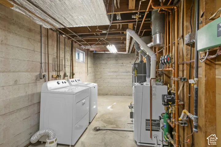Utility space featuring concrete walls, a small window, exposed copper piping, and a visible water heater