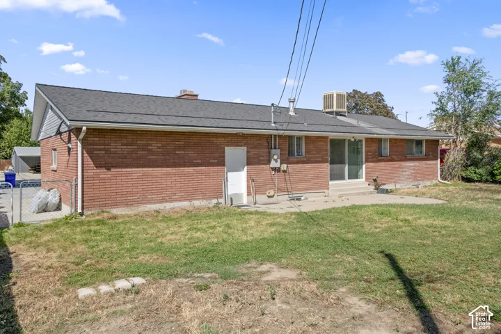 Red brick exterior with a dark shingle roof, chimney, and white gutters