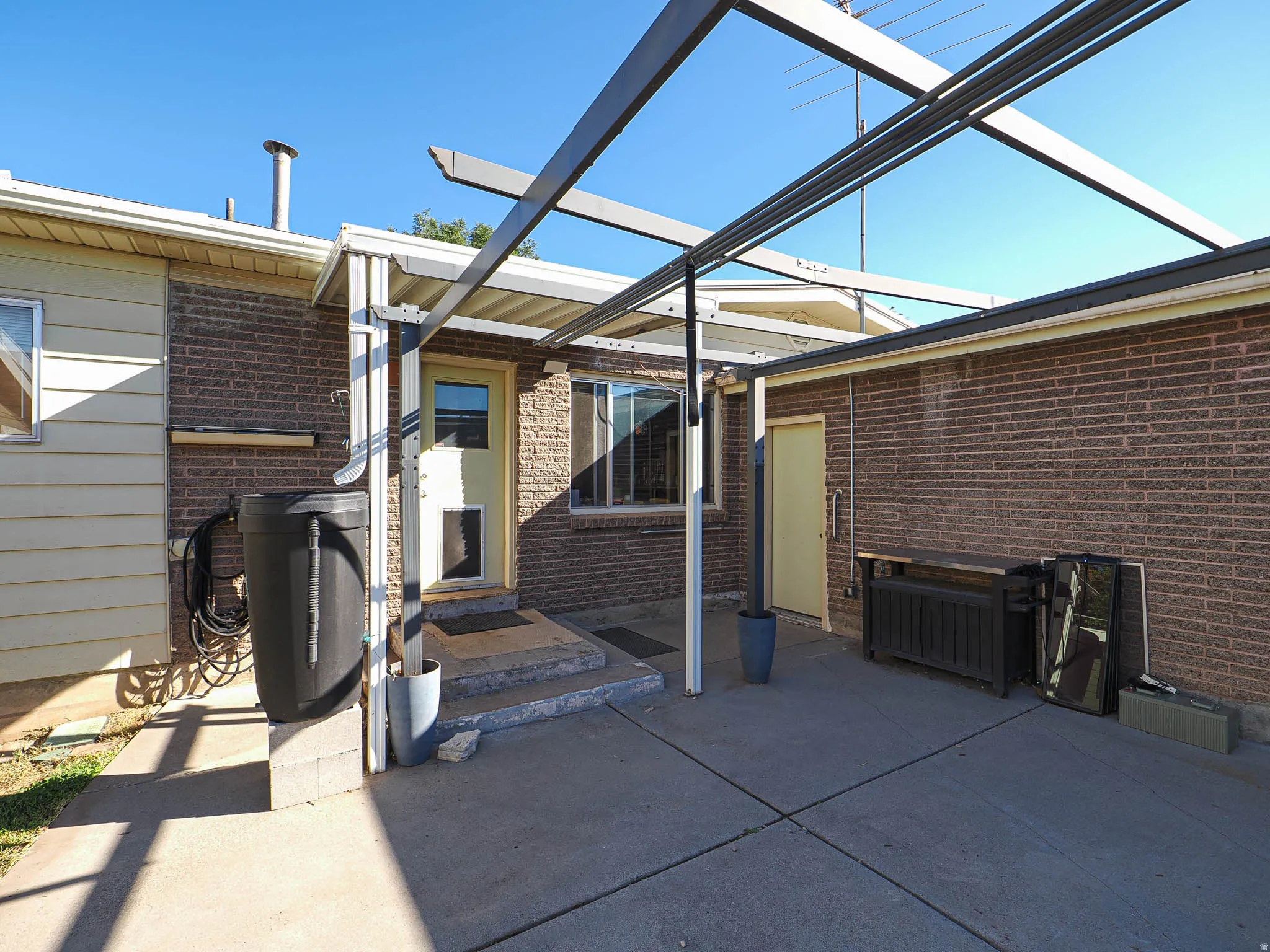 Patio with rain catching barrels leading to kitchen door.