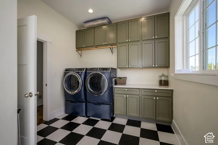 Laundry space featuring checkerboard flooring, extensive cabinetry, a built-in countertop, and a window with grid detailing