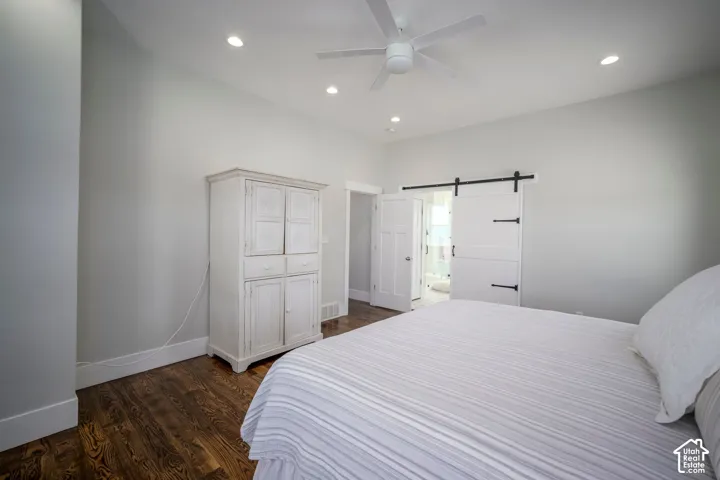 Hardwood flooring, recessed lighting, ceiling fan, and sliding barn door