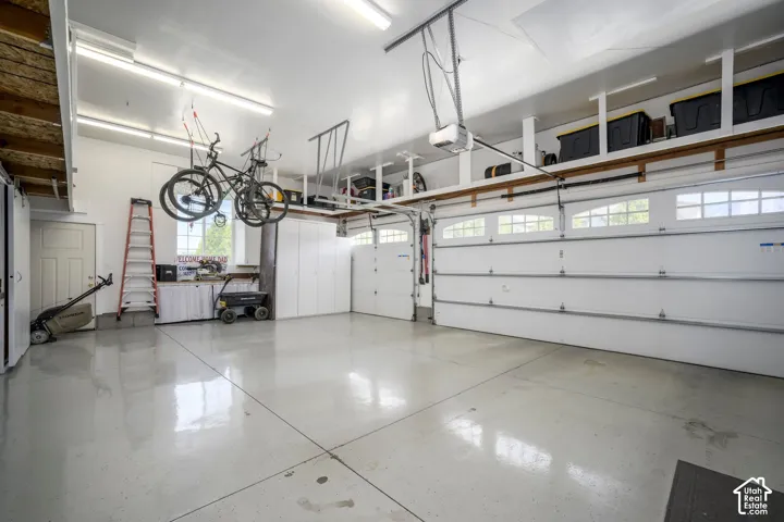 Two-car garage with overhead storage, built-in cabinetry, and a window for natural light
