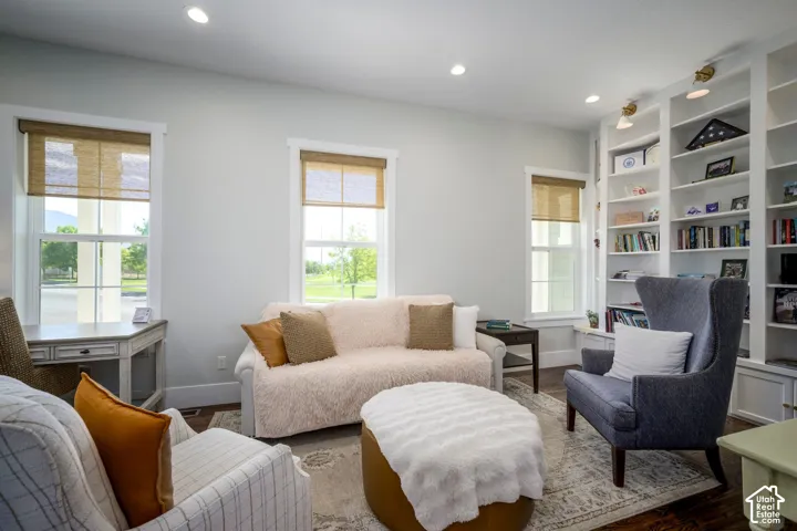Recessed ceiling lighting, wood-finish flooring, built-in shelving, sconce lighting, and multiple windows