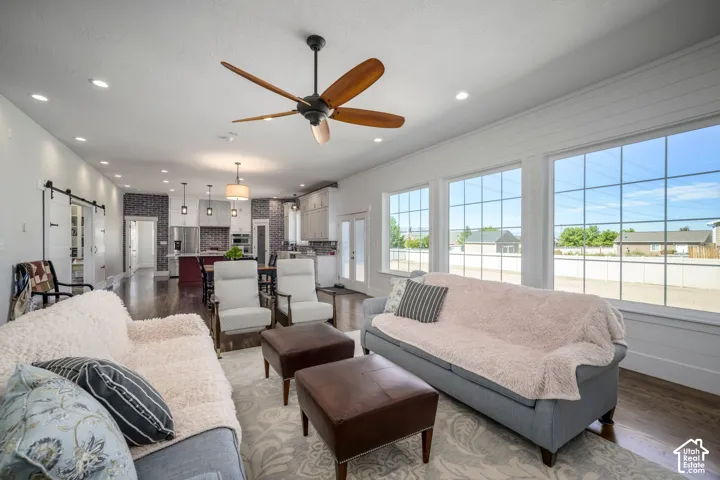Recessed lighting, wood-finish flooring, and multiple large windows with grid accents