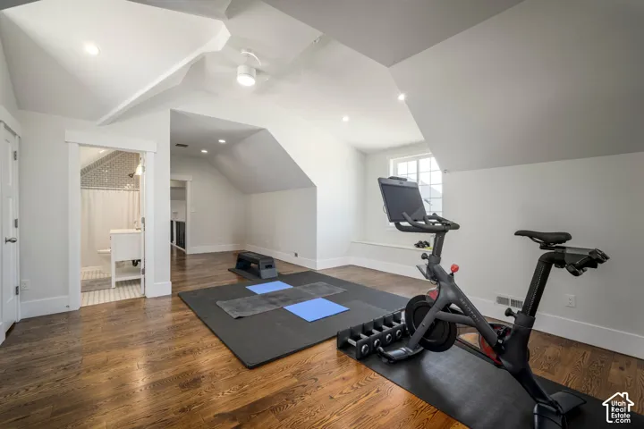 Hardwood flooring, recessed lighting, sloped ceilings, built-in window bench, and an attached full bathroom with a tiled shower
