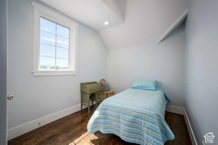 Hardwood-finish flooring, recessed ceiling lighting, a window with grid detailing, and a built-in wall shelf