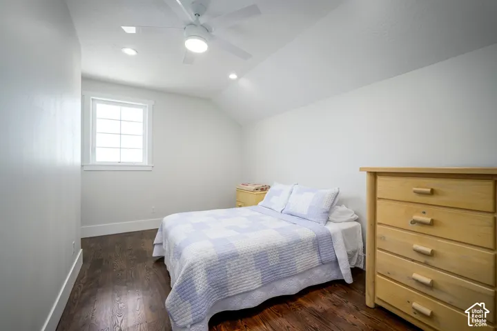Angled ceiling featuring recessed lighting, a ceiling fan, a window, and wood-finish flooring