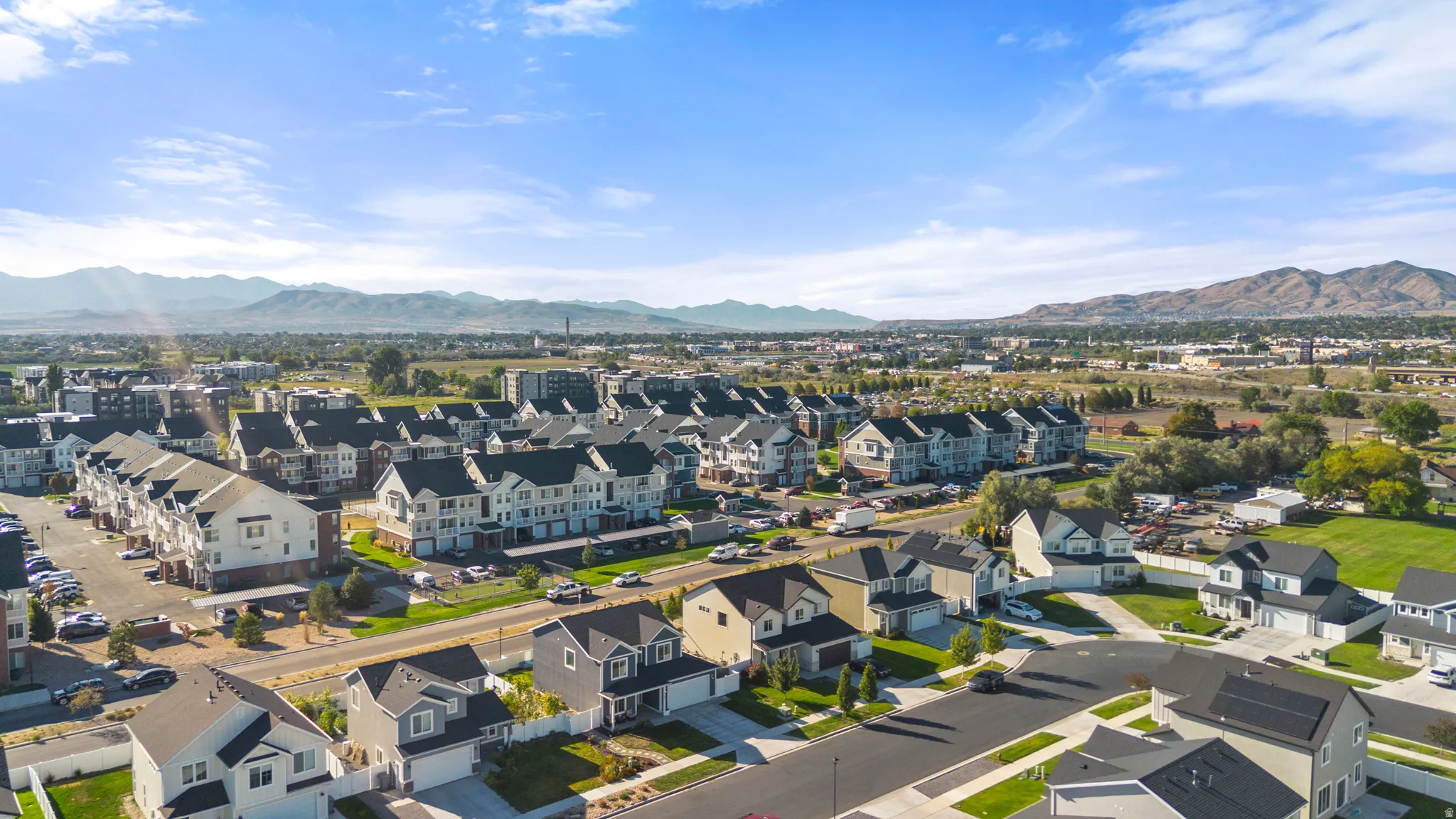 Suburban neighborhood featuring varied housing styles, established streets, and distant mountain ranges