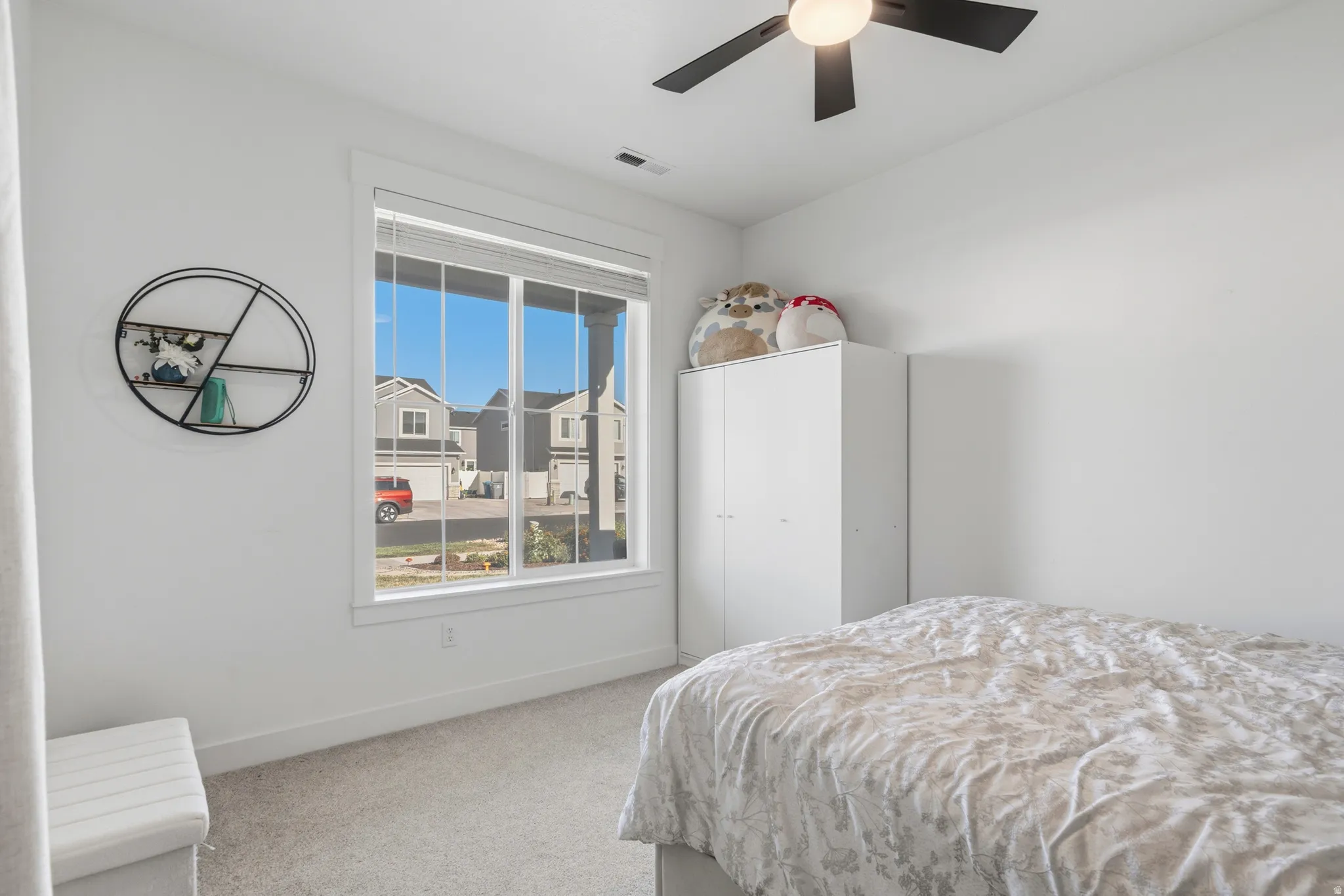 White walls, carpeted flooring, and a large window with white trim