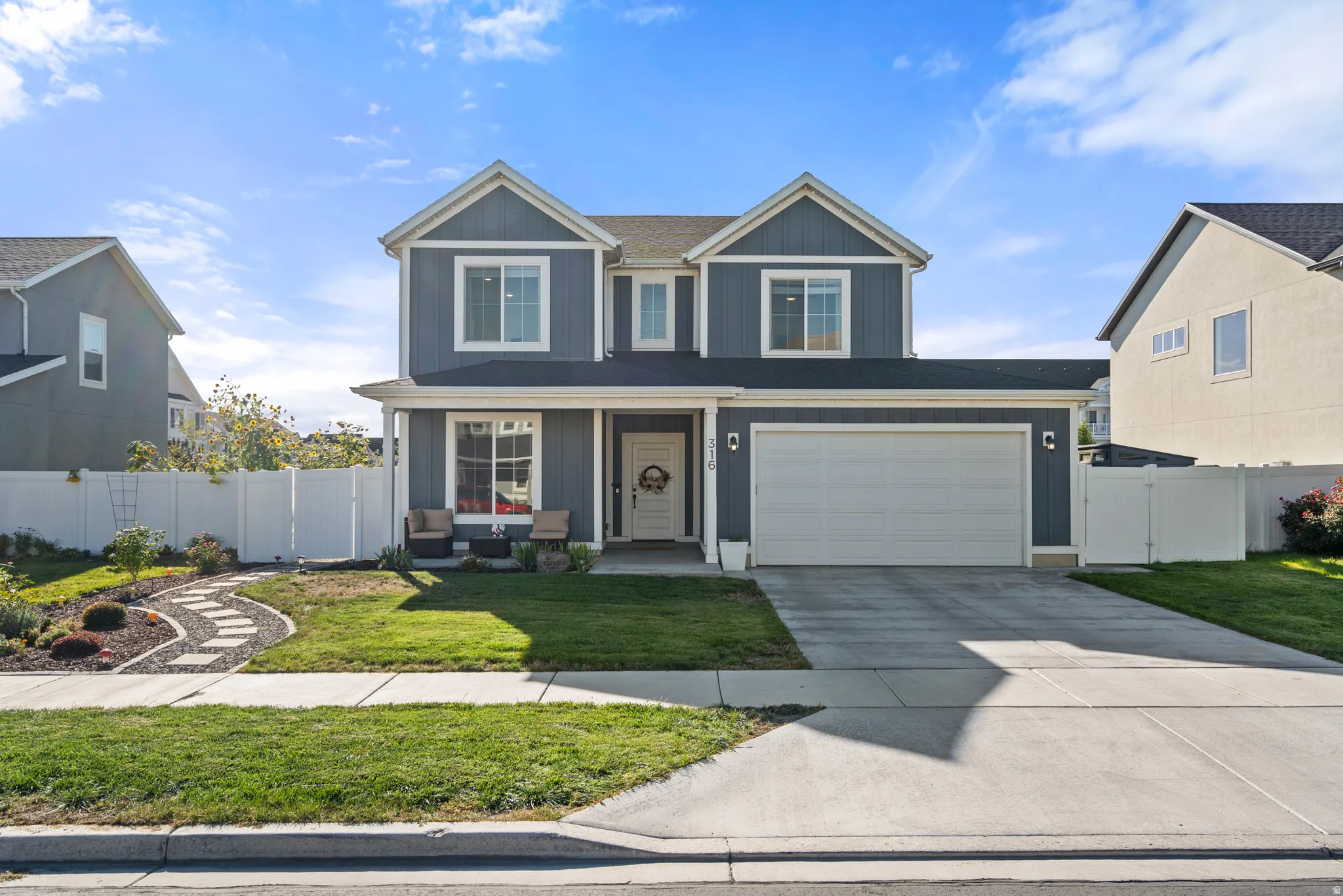 Contemporary two-story exterior with horizontal siding, a two-car garage, and a concrete driveway