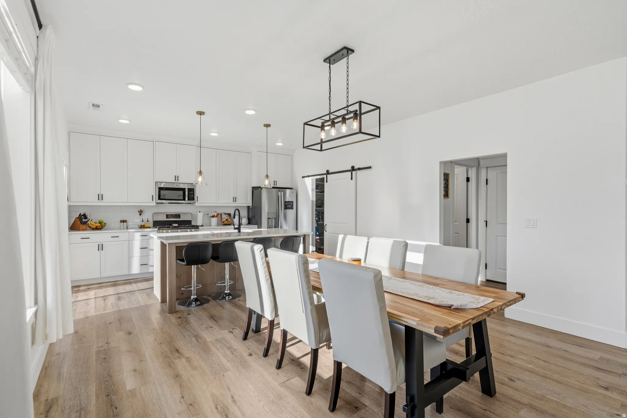 Open-concept dining and kitchen with wood-finish flooring