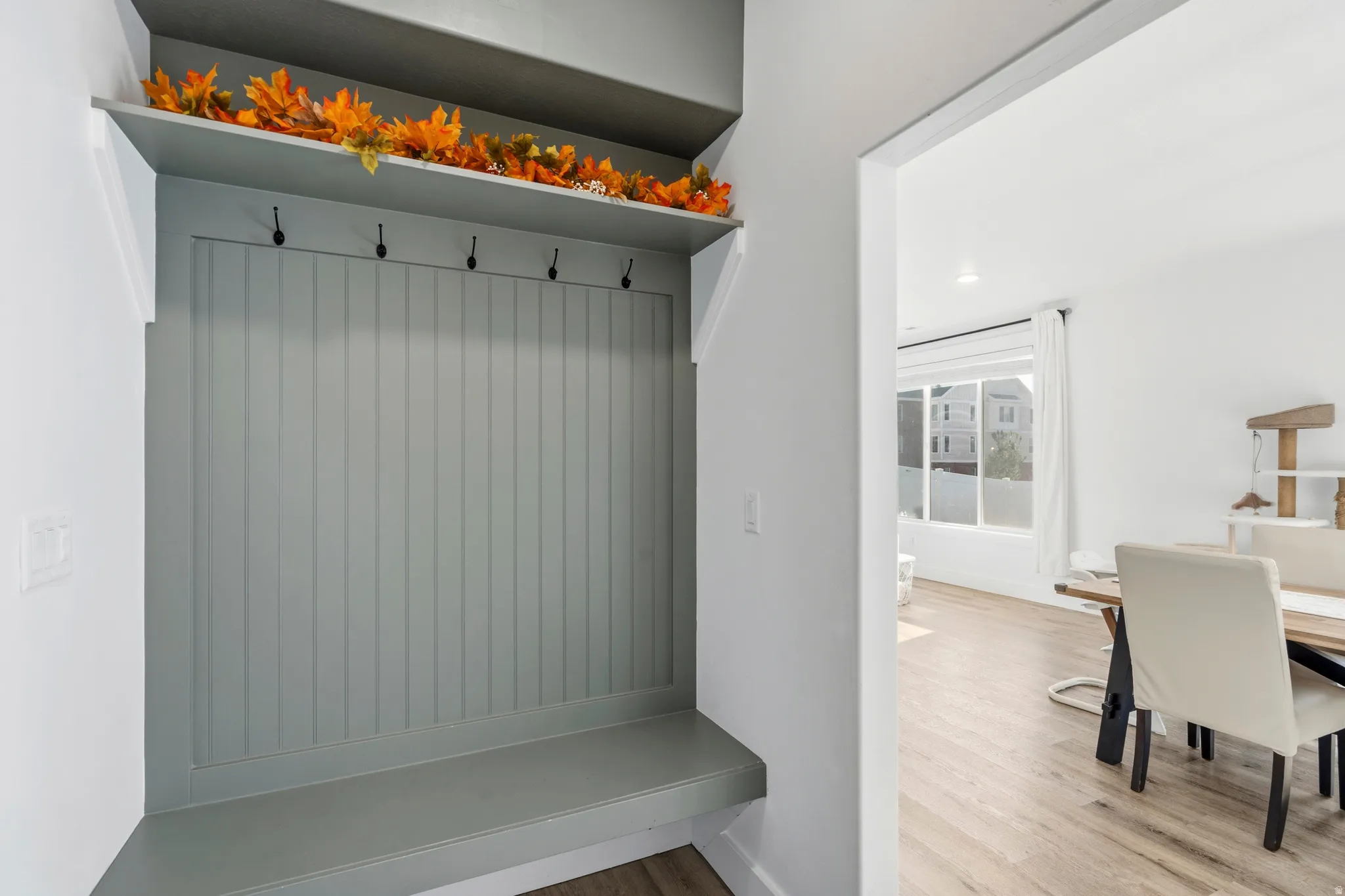 Built-in entryway bench with vertical paneling and upper shelf