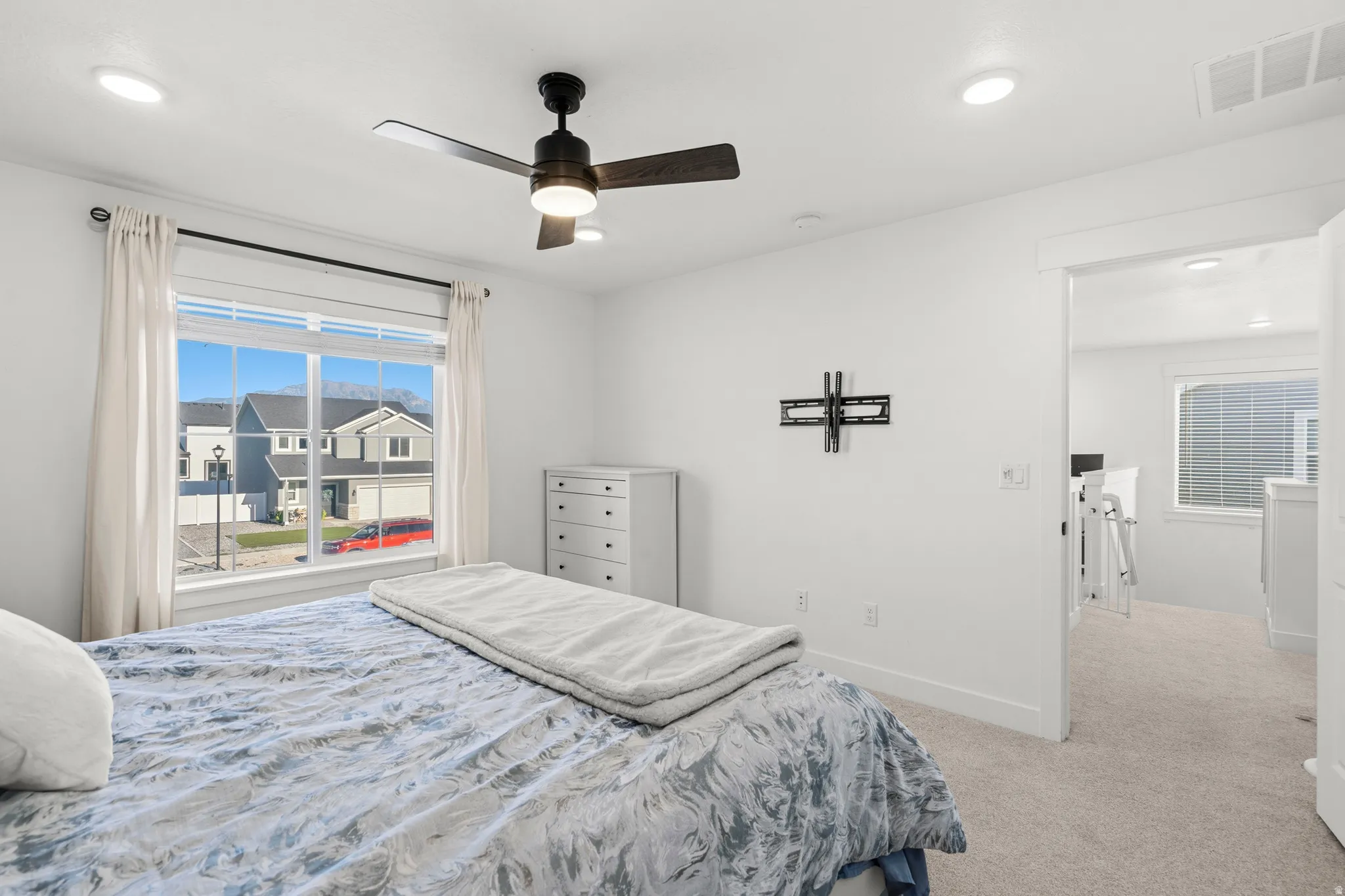 Recessed lighting, ceiling fan with integrated light, window with white trim, and a doorway leading to an additional space
