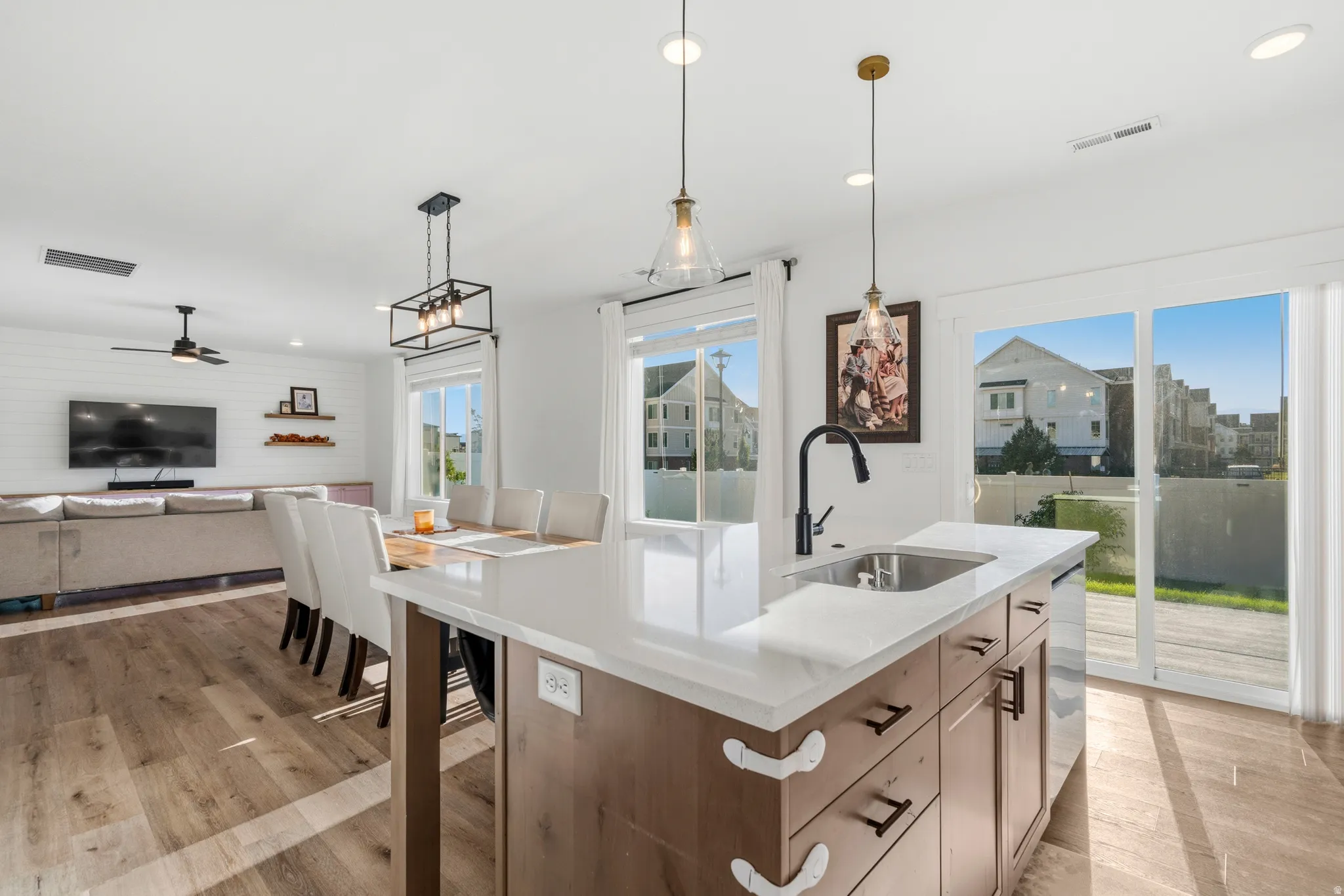 Kitchen island with a stainless steel sink, a matte black faucet, and pendant lighting